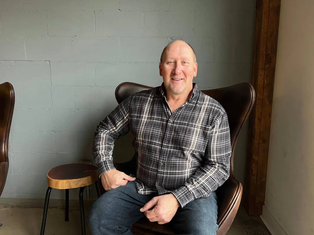 Paul Martens seated in a leather armchair